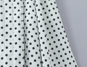 Détail macro du tissu à pois blancs avec un élégant drapé plissé en mousseline fine