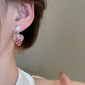Close-up of pink resin strawberry earring with sparkling glitter and zircon stud on ear