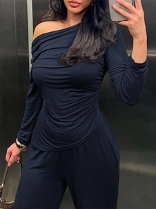 Detail of elegant navy off-shoulder pleated long-sleeve top and matching pants set
