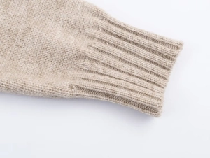 Detailed macro view of the ribbed cuff on an oatmeal colored soft knit sweater jacket