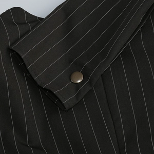 Macro shot of sleeve cuff with vertical stripes and bronze cylindrical metal button