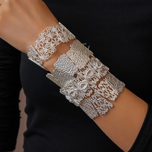Detail of silver matte cuff bracelets with floral hollow carvings and hammered texture