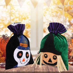Halloween ghost and scarecrow themed felt candy gift bags on a wooden table setup
