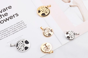 Detailed view of tree of life pendants in gold and silver finish on a magazine background