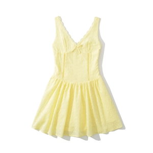 Détail de la broderie anglaise jaune et du nœud sur une robe à col en V