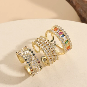 Detailed close-up of three 14K gold plated rings with pearls and colorful zircons