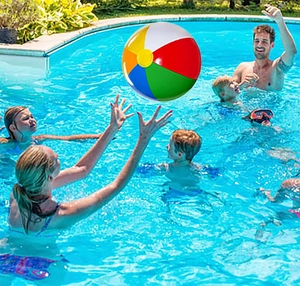Family playing with a colorful inflatable PVC rainbow beach ball in an outdoor swimming pool