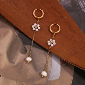 Detail of 18K gold plated earrings with delicate pearl flower and hanging baroque pearl