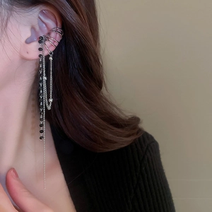 Détail de manchette d'oreille argentée avec chaîne à franges et perles noires