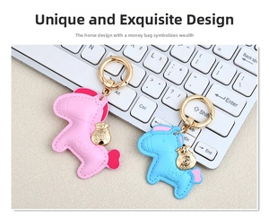 Close-up of horse-shaped leather keychain charms in pink and blue with gold money bag detail