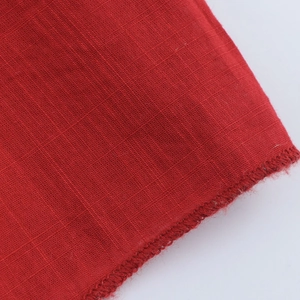 Vue macro du tissu en lin et coton rouge avec couture et texture tissée