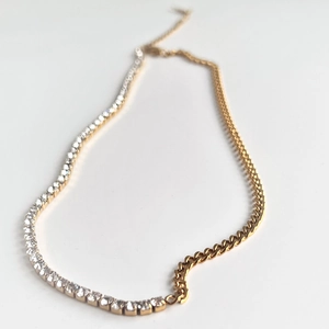 Detailed shot of 18k gold plated cuban link necklace with zircon pave tennis chain