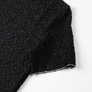 Dettaglio dell'elegante tessuto in pizzo nero con intricati motivi floreali traforati