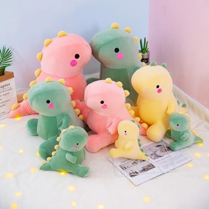 Group display of plush dinosaur pillows in pink, green and yellow with soft fabric details