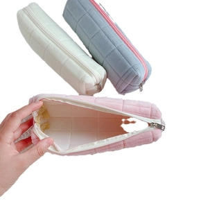 Plush checkered pencil case set in cream, blue and pink with hand showing interior
