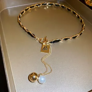 Faux leather woven chain necklace with gold letter plaque and pearl pendant
