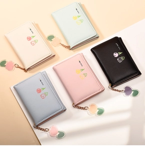 Detailed view of five pastel leather wallets with tulip prints and peach zipper charms