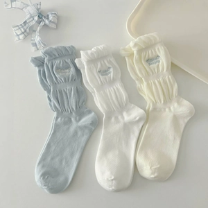 Three pairs of ruffle knit socks in pastel blue and white with embroidered bow details