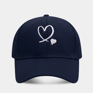 Detailed view of dual heart embroidery on navy cotton twill baseball cap with stitching