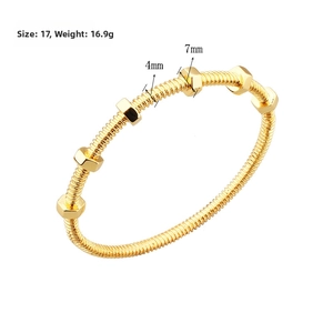 Macro detail of industrial style bolt bracelet in gold finish with moveable nuts
