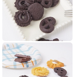 Detailed view of realistic chocolate cookies and resin biscuit food props on a ceramic plate