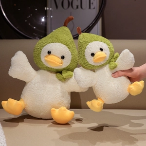 Peluche canard avec chapeau poire mignon en deux tailles sur un canapé beige