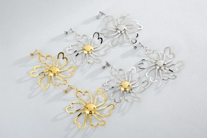 Detailed view of large gold and silver daisy earrings with hollow heart-shaped petals