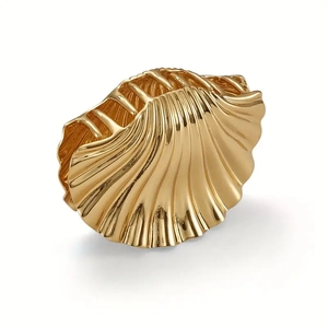 Golden metal shell hair claw clip for elegant beach hairstyles on a white background