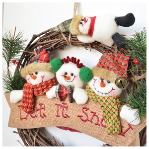 Detail of Let It Snow banner on a Christmas wreath with plush snowman and pine needles