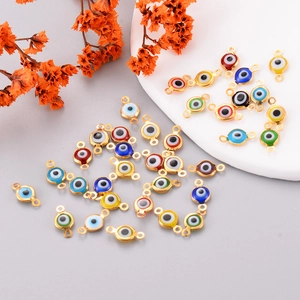 Macro shot of colorful evil eye charms with gold plating and dual connectors for DIY jewelry