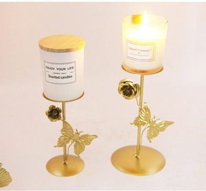 Detail of golden metal candle holders with rose and butterfly motifs and scented candles