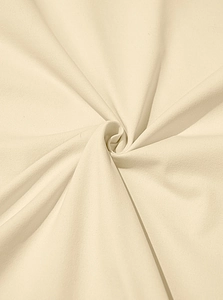 Detailed macro view of soft cream-colored knit fabric with spiral texture and fold