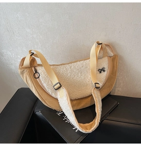 Detail view of the fuzzy crescent crossbody bag with lamb wool and bow accents