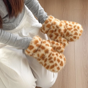 Close-up of plush giraffe print mittens made of thick faux fur for winter warmth