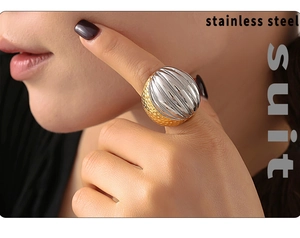 Detailed macro of a two-tone statement ring in gold hammered and silver striped texture