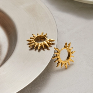 Detailed shot of 18K gold stainless steel sun earrings with irregular radiant ray design