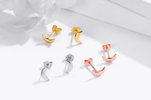 Macro detail of crescent moon stud earrings showing S925 sterling silver hallmarks