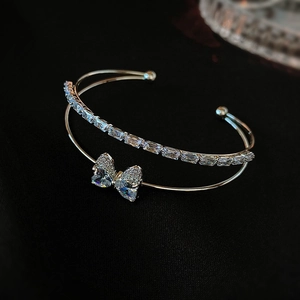 Detail showing bow-shaped heart zircon on double-layer silver open bangle bracelet