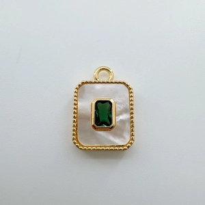Macro shot of a 18K gold plated rectangular pendant with green gemstone and shell inlay
