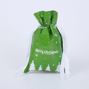 Green Christmas drawstring gift bag with white snowflakes, tree patterns and ribbon closure
