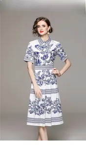 Détail d'imprimés floraux et d'oiseaux bleus sur une robe midi blanche chic