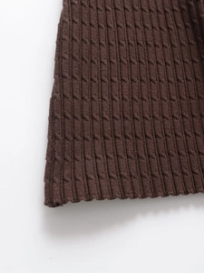 Makroaufnahme von dunkelbraunem Zopfmuster auf diesem schmalen Strickkleid