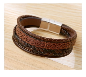 Detailed macro view of multi-layer brown leather braided bracelet with silver metal buckle