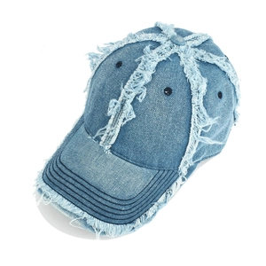 Detail of frayed edges and distressed denim texture on a light blue vintage baseball cap