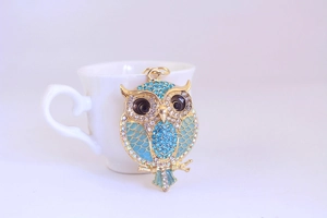 Macro shot of owl keychain with blue enamel and sparkling crystal rhinestones