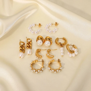 Flat lay of multiple 18K gold plated stainless steel hoop earrings with white pearls