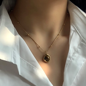 Vintage stainless steel necklace with tiger eye stone pendant worn by a model