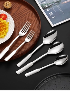 Close-up of polished 304 stainless steel spoons and forks on a wooden tray