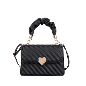 Fashionable black quilted PU leather handbag with heart buckle and pleated handle on white background