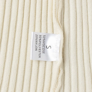 Detail of ribbed knit fabric texture and care label showing S size and material composition
